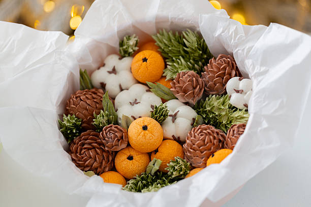 istock Zephyr arrangement featuring pine cones, cotton bolls, and oranges nestled in white tissue paper, creating a festive atmosphere with natural elements and seasonal charm 2254597016