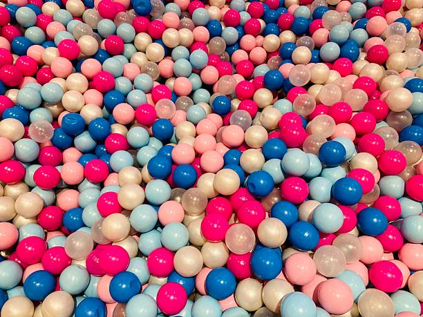 Happy girl having fun playing in a ball pool and smiling