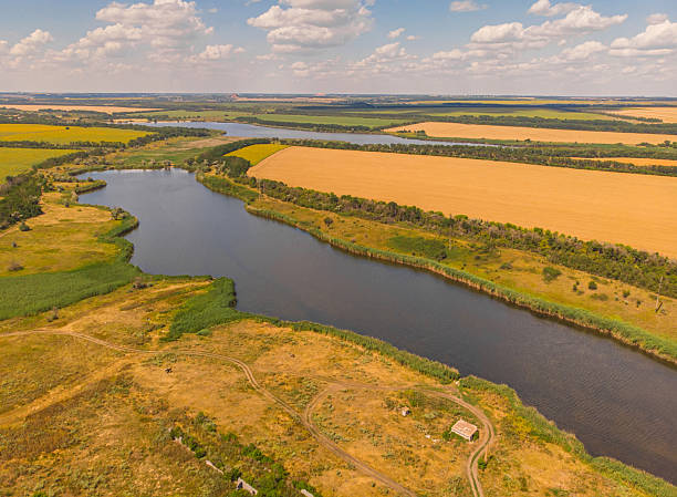 istock Beautiful view to the wheat fields with river and forest 2254599097