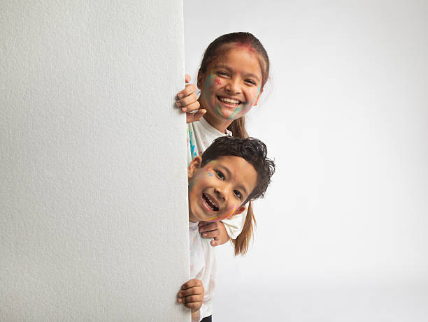 Two children enjoying their time outdoors while posing against a stone wall. They seem playful and happy in Nin, Croatia.