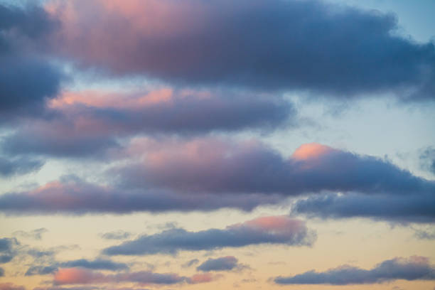 Stunning evening sky filled with soft pink and blue clouds at sunset creating a peaceful and serene natural background atmosphere.High quality photo