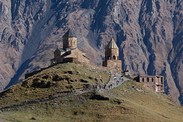 istock Gergeti Trinity Church On Hill With Rocky Mountain Background 2254607154