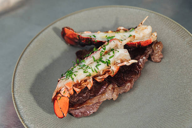 Luxurious Seafood Dish, Sumptuous Lobster Tail Served Alongside Perfectly Cooked Steak With Herbs