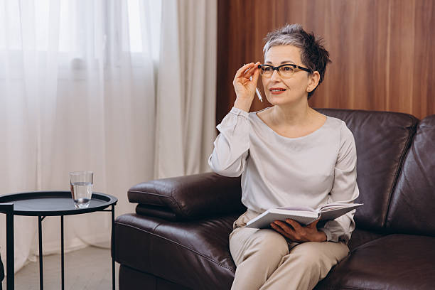 istock Senior woman psychologist adjusting glasses, holding notebook 2254618956