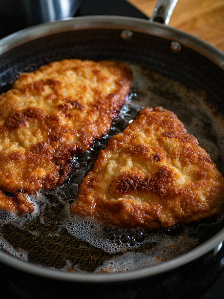 istock Frying crispy breaded chicken cutlets in frying pan, close-up 2254621192