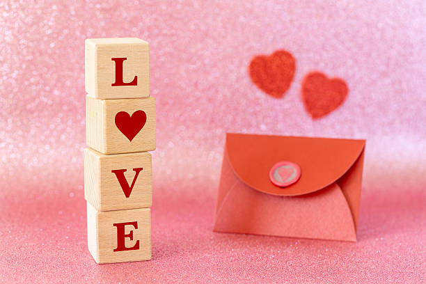 Romantic background. A red envelope with a love declaration, Valentine's hearts. A declaration of love to the closest person. The word LOVE on wooden blocks