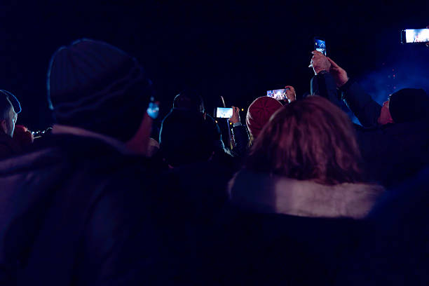 A joyful moment captured as a person takes a selfie with a masked figure during a night event, blending cultural celebration with personal interaction and enjoyment.