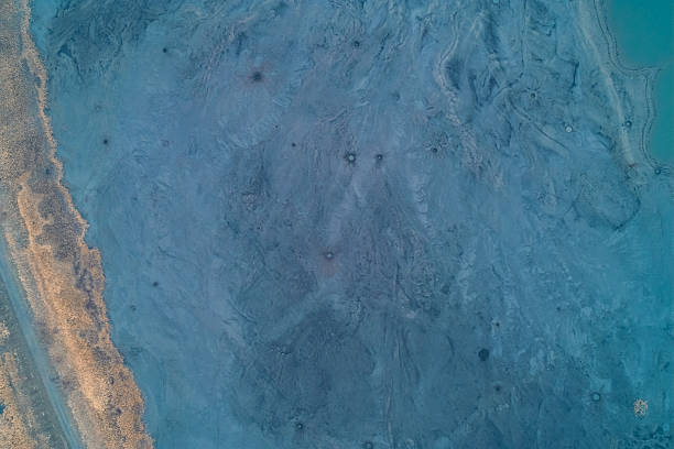 istock Aerial top down view of blue pockmarked sludge surface with small craters. Toxic waste texture and surreal alien landscape background. 2254629073
