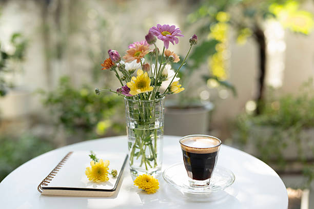 istock Chrysanthemum flowers and coffee and notebook on a white table, serene garden 2254630272