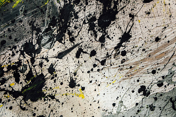 istock Black and yellow paint splashes cover a white surface in an abstract style at an art studio 2254637166