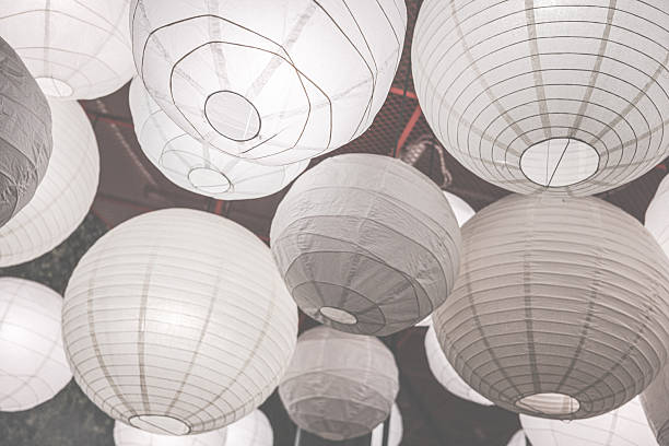 istock Warm glowing paper lanterns hanging from ceiling in dark interior. 2254637953