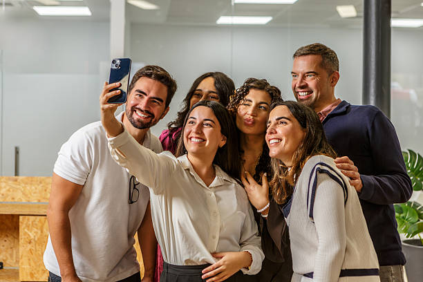 istock Group of people taking a selfie in a modern coworking space 2254639610