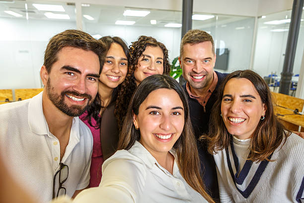 istock Group of colleagues taking a selfie in a modern coworking space 2254639702