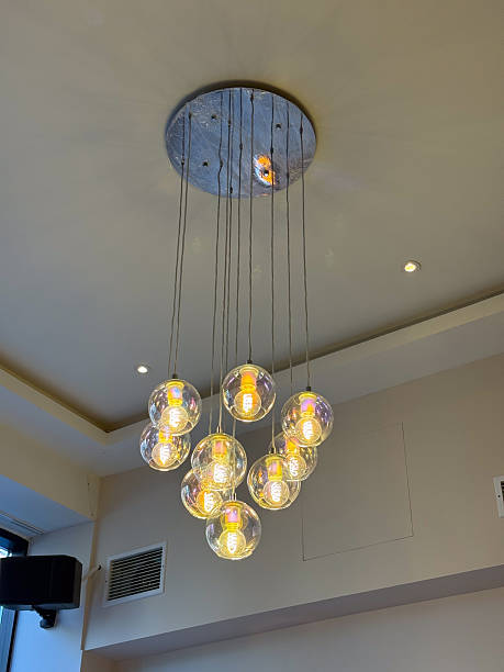 istock Hanging chandelier with glowing bulbs. Interior ambiance, soft illumination, decor structure, elegant lighting and warm modern design. 2254639828