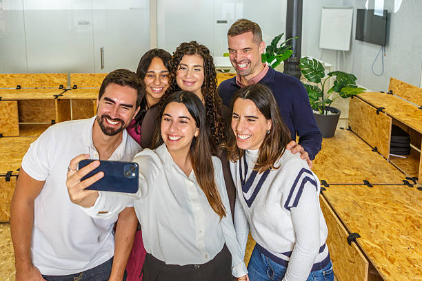 istock Group of colleagues taking a selfie in a modern coworking space 2254640189