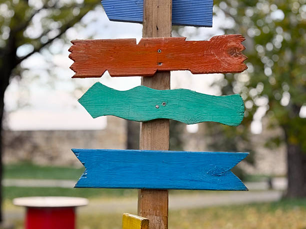 istock Colorful wooden arrows on post. Creativity, freedom, and joyful navigation concept 2254640411