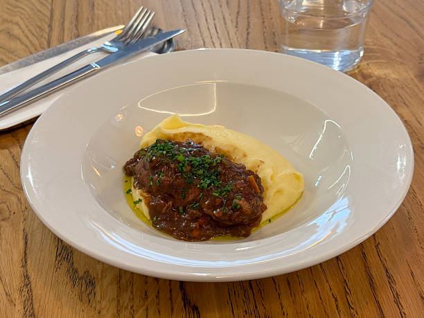 istock Beef stew with mashed potatoes served in white bowl on wooden table. Boeuf bourguignon. Comfort food lunch 2254640431