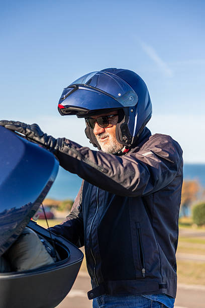 istock vertical Senior man with motorcycle helmet adjusting gear for journey 2254644209