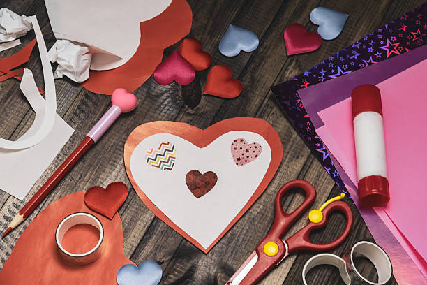 istock Valentine's Day greeting card with red and white hearts. Scissors, glue stick, colored sheets of paper 2254646657