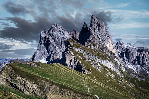 The impressive Langkofel or Sassolungo mountain in the Italian Dolomites seen from Seceda during a springtime day in the Italian Alps.