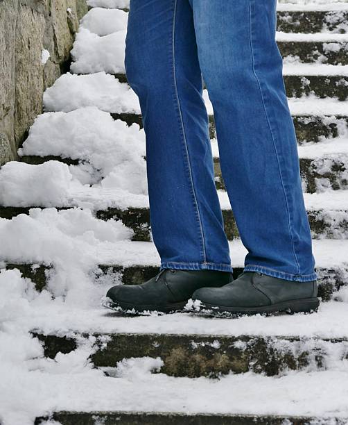 istock Man walking the tairways down with snow 2254651640