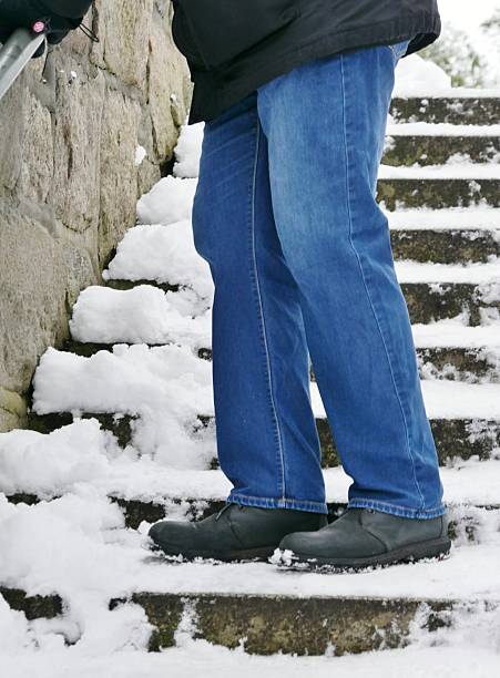 istock Man walking the tairways down with snow 2254651652