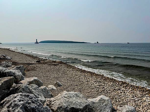 istock Wide View of Stony Beach and Distant Lighthouse 2254653064