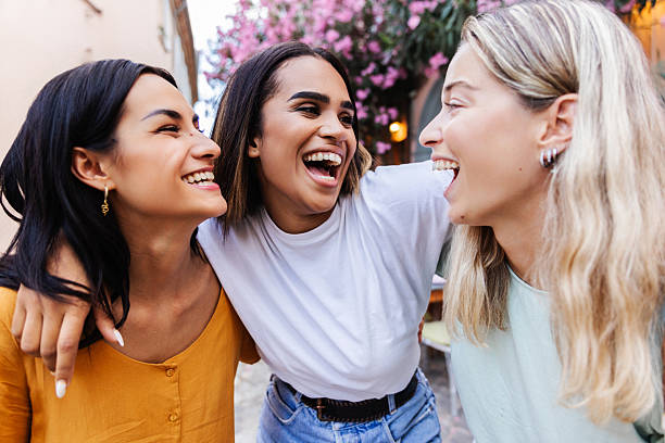 istock Three young women laughing together outdoors 2254655171