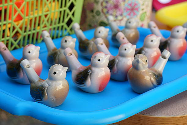 Many clay birds-whistles on a tray.