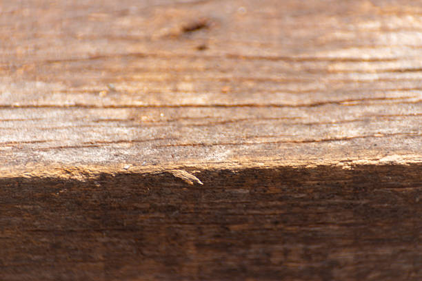 The wood grain is rough and uneven. The wood is brown and has a natural texture. The grain is visible in the wood, giving it a rustic appearance