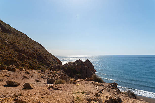 A beautiful blue ocean with a rocky cliff in the background. The ocean is calm and peaceful, and the cliff adds a sense of grandeur to the scene