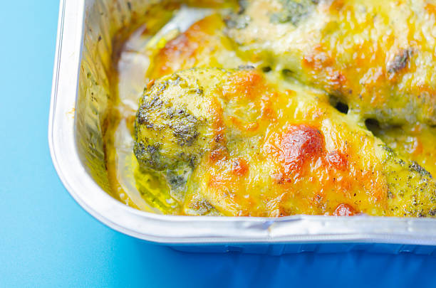 A dish of chicken and cheese is sitting in a baking tray. The dish is covered in cheese and has a crispy texture