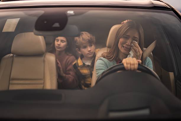 istock Single mother crying while driving car with children 2254669179