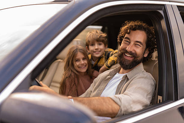 istock Family enjoying road trip together, smiling from car 2254669727