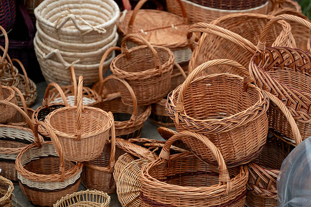 Assortment of Handwoven Wicker Baskets in Rustic Setting. Handmade natural braided containers in various sizes and shapes arranged together on textured background.