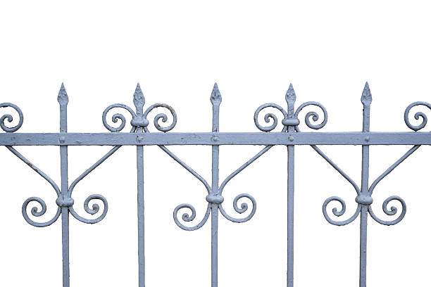 A section of a decorative wrought iron fence with symmetrical scrollwork and pointed finials, isolated on a white background. The elegant and classic design showcases craftsmanship and adds a touch of vintage charm to the composition.