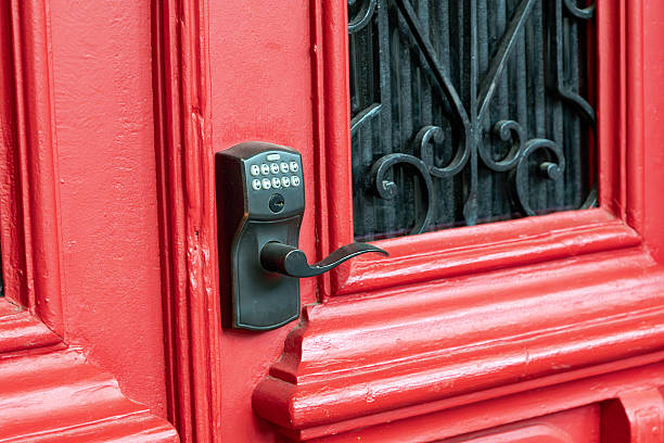 istock Red wooden door featuring a modern electronic keypad lock and handle, providing keyless entry and enhanced security for a smart home 2254671370