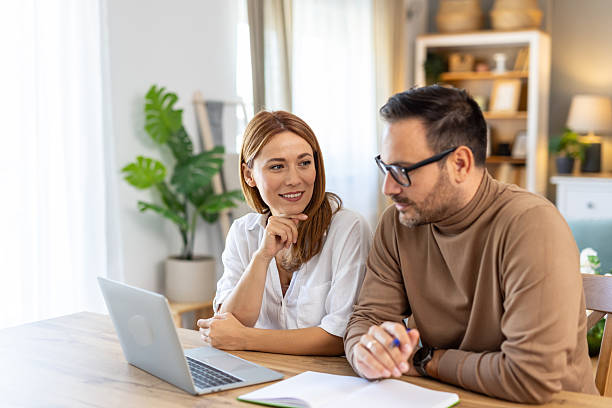 istock Couple discussing ideas over laptop in bright modern home. 2254671708