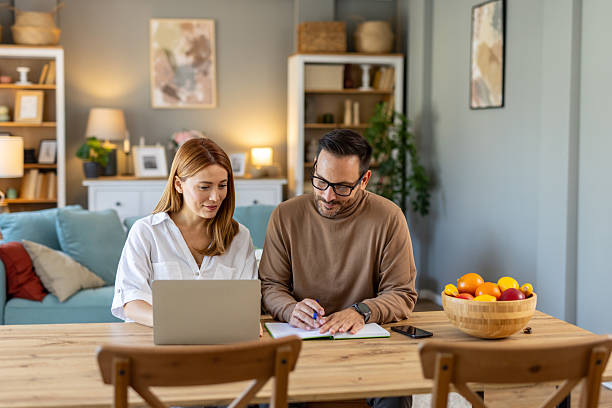 istock Couple collaborating on a project at their wooden dining table. 2254671710