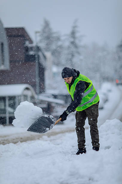 istock Man in high visibility vest shoveling snow during a winter storm 2254673199