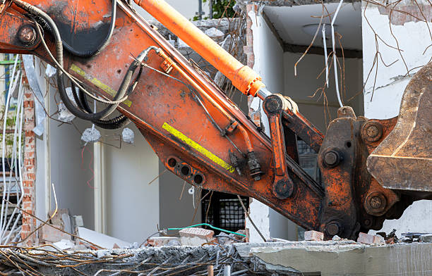 Pile of concrete in front of partially demolished house. Focus on foreground.
