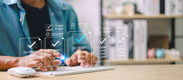 istock Businessman using digital checklist interface on tablet and laptop. Concept of online document verification, approval workflow, electronic forms, task management, and digitalization. 2254696693