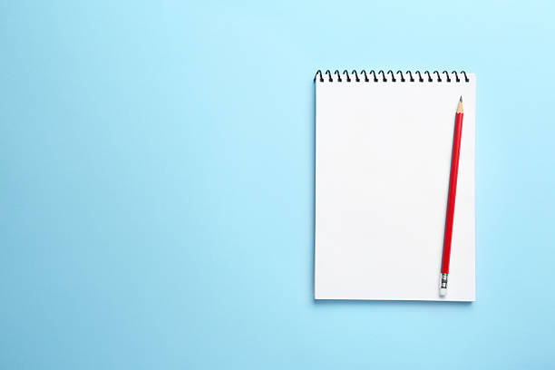 istock Notebook and pencil on light blue background, top view. Space for text 2254698170