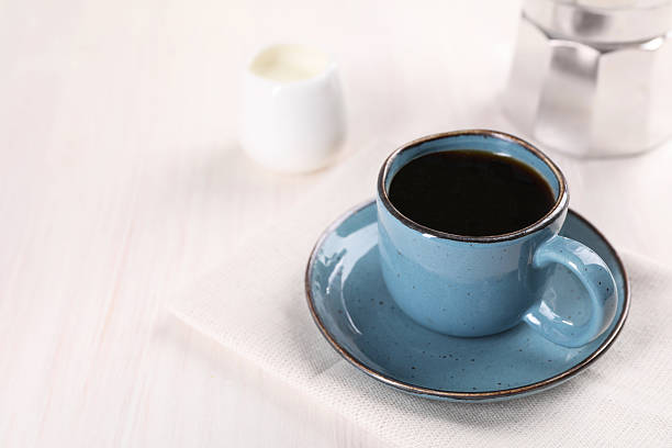 Delicious coffee in cup on white wooden table, closeup. Space for text