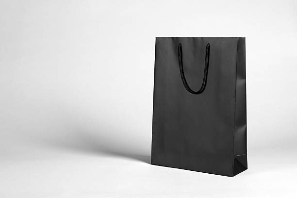 istock One black paper shopping bag on grey background. Space for text 2254707713