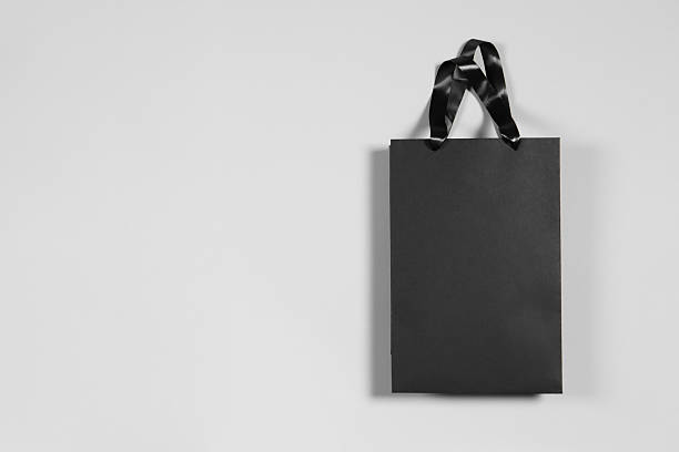 istock One black paper shopping bag on grey background, top view. Space for text 2254707723