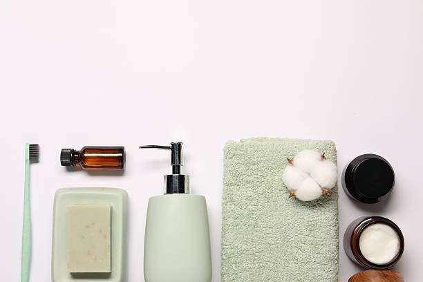 istock Bath accessories. Different personal care products and cotton flowers on white background, flat lay with space for text 2254710307