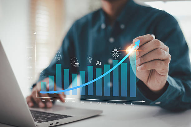 istock businessman use  draw a rising, illuminated blue arrow over a bar graph displaying monthly growth, symbolizing successful business startup strategy, AI technology integration, and achieving ambitious target goals. 2254711722