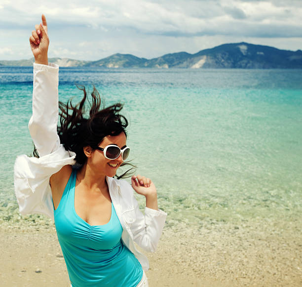 Happy girl jumping on the beach, summer holiday