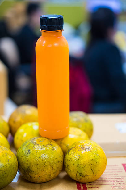 Clear Plastic Bottle Filled with Fresh Organic Orange Juice and Black Cap